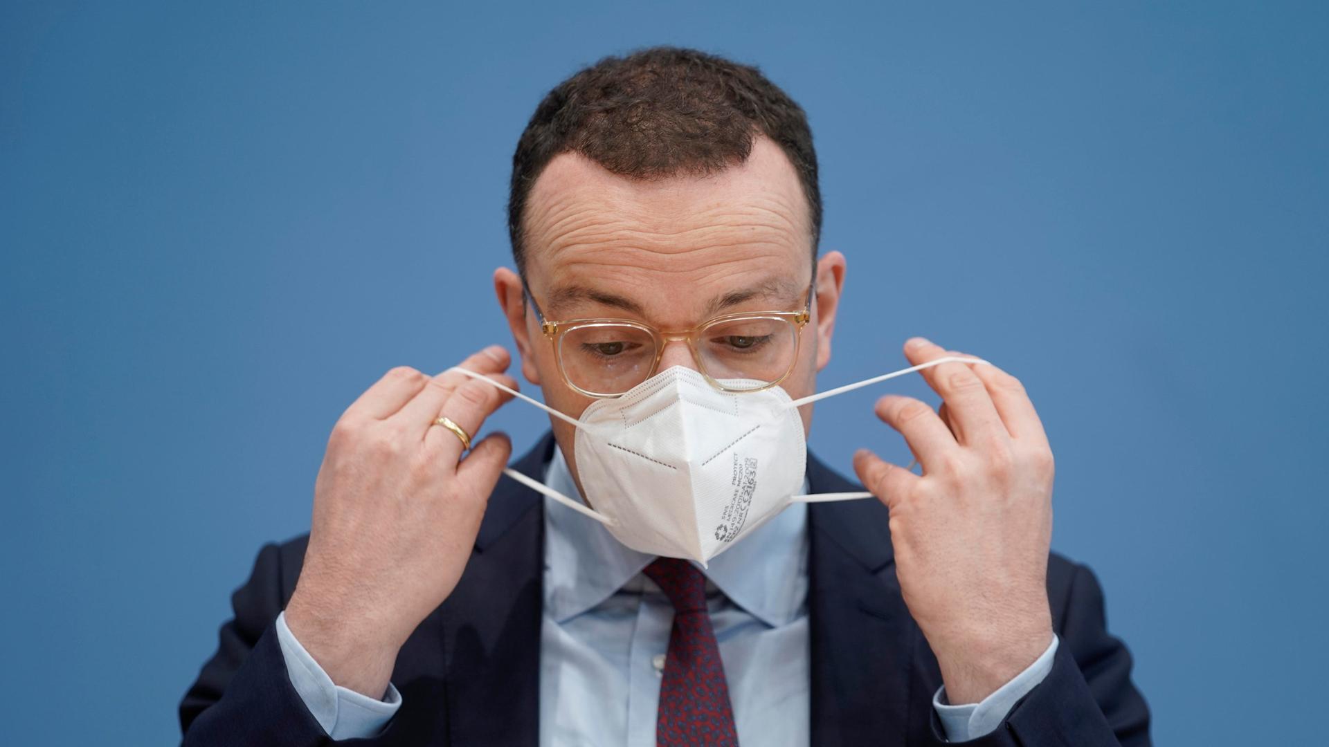 Der damalige Bundesgesundheitsminister Jens Spahn im Portrait beim Aufsetzen seiner FFP2-Maske bei der Bundespressekonferenz zum Thema Corona-Lage im November 2021.